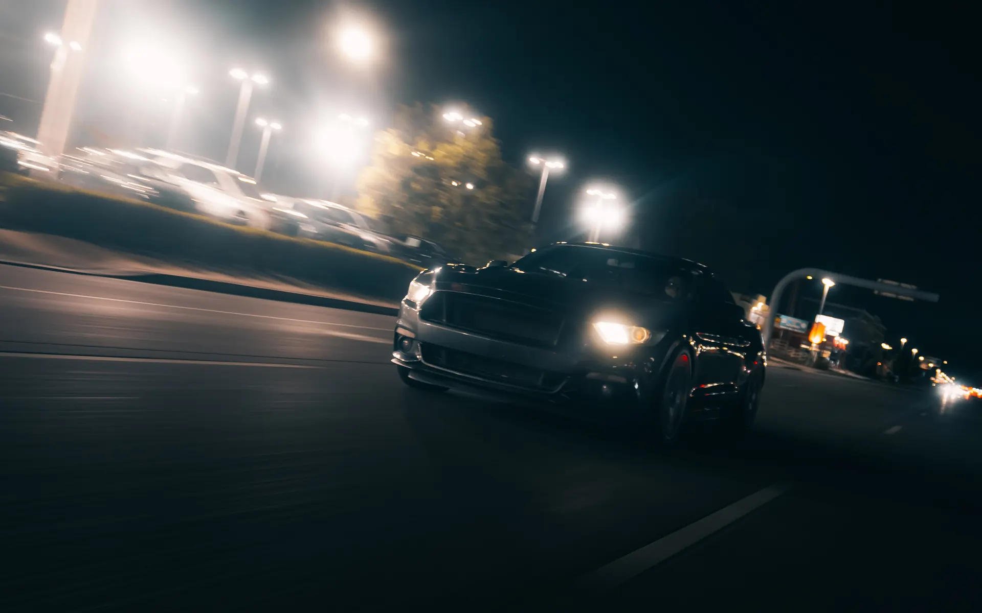 A car rolling down a lit street at night
